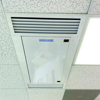 Ceiling-mounted air conditioning unit with 'Breezomatic' branding on a ceiling with speckled finish.