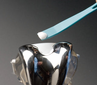 Metallic object with a blue Heathrow Scientific OR1205 Plastic Curette, Whitney Valitome on a gray background