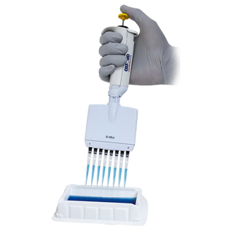 Oxford Multichannel pipette with gloved hand holding it above a white background