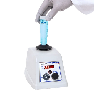 Oxford BenchMate VM-D Digital Vortex Mixer with digital display and blue liquid being stirred by a gloved hand.