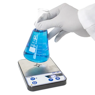 Hand in a white glove holding a beaker with blue liquid over a Oxford Benchmate MS1 Magnetic Stirrer on a white background