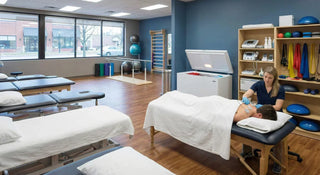 Modern physical therapy clinic featuring treatment tables, electrotherapy devices, and hot/cold therapy equipment.