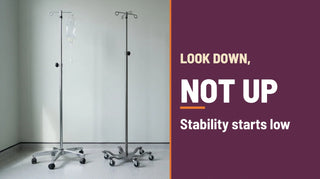 Look down, not up: a five leg chrome IV pole and a six leg stainless steel spider IV pole in a clinic infusion room