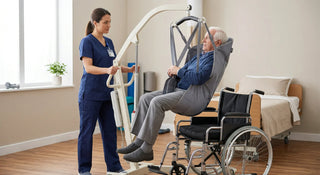 Healthcare worker using a full-body patient lift to safely transfer a suspended patient toward a wheelchair in a clinical care setting