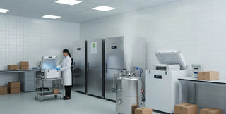 Scientist using a portable ultra-low temperature freezer in a modern laboratory with cryogenic storage equipment.