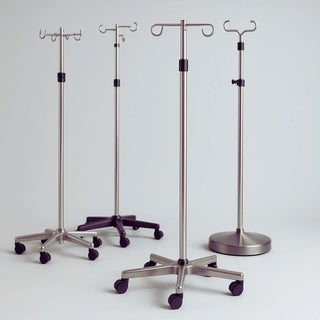 Adjustable stainless steel IV pole with wheels, 5-leg base and 4 hooks in hospital exam room