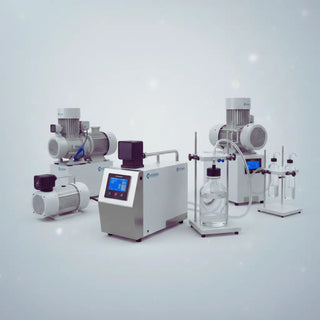 Laboratory vacuum pump connected to a benchtop aspiration system with collection bottle on a biosafety cabinet work surface.