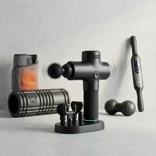 Physical therapist using a handheld percussion massage gun on a patient's shoulder for deep tissue pain relief.