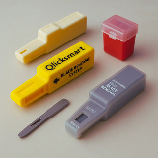 Single-handed scalpel blade remover device mounted on a bracket, with sterile blade removal cassette and puncture-proof sharps container used in the OR