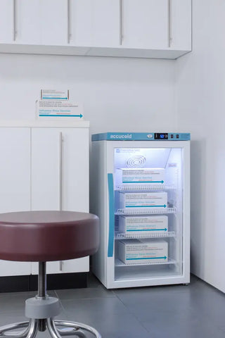 RAccucold ARG3PV Vaccine Refrigerator with shelves in a room with a stool and cabinets.