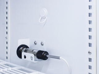 Mechanical component attached to a white metal structure with a cable.