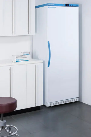 Large white Upright Pharmacy Vaccine Refrigerator with blue accents in a room with cabinets and a stool.