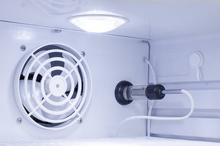 Close-up of a refrigerator interior with a fan and light bulb.