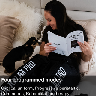 Woman reading the Air Relax Pro user manual while wearing the leg sleeves