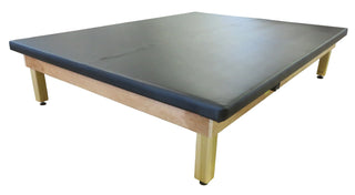 Bailey Manufacturing Model 4124/4125/4126/4127 Economy Electric Hi-Lo Upholstered Mat Tables with a black top and wooden base on a white background