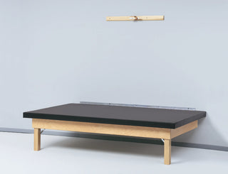 Bailey Manufacturing Model 458 Wall Mounted Mat Platform with black mattress against a light gray wall.
