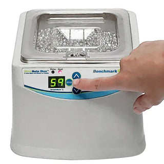 Hand pressing a button on a Benchmark Scientific BeadBath Duo™ Bead/Water Baths with a digital display.