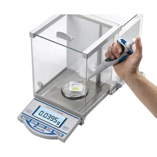 Digital scale being used to measure a liquid with a hand holding a Benchmark Scientific NextPette™ Precision Pipette.