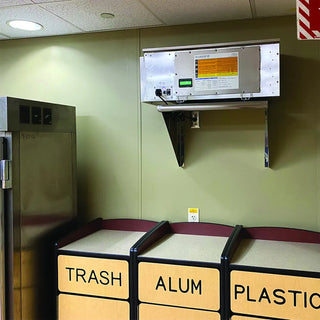 Trash bins labeled 'TRASH', 'ALUM', and 'PLASTIC' with a wall-mounted electronic device above them.