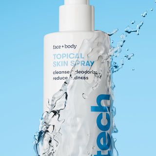 Topical skin spray bottle with water splash on a blue background