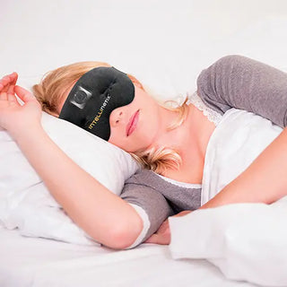 Black Intellinetix Therapy Eye Mask with embedded vibration module, adjustable head strap, breathable cotton fabric, and ergonomic eye contour with ergoBeads technology.