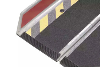 Close-up of a Clarke Healthcare MPEBXX DECPAC Fiberglass Portable Wheelchair Van Ramp with Edge Barrier with red, yellow, and gray warning pattern on a white background
