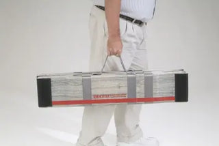 Person holding a closed up and in the bag Clarke Healthcare MPEBXX DECPAC Fiberglass Portable Wheelchair Van Ramp with Edge Barrier with a red stripe on a white background
