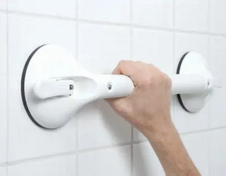 Hand holding a white Clarke Healthcare R140022XS Mobeli Telescoping Shower Grab Bars against a tiled wall