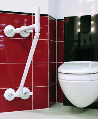 White toilet with a white Clarke Healthcare R140026XSU Mobeli Bathtub Support Long Grab Bar against a red tiled wall.