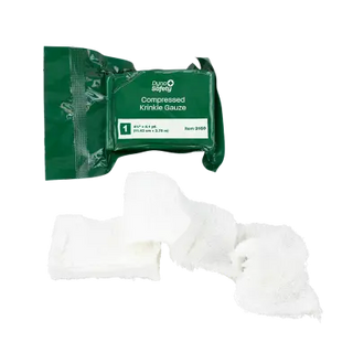 Green package of compressed krinkle gauze with white gauze on a white background