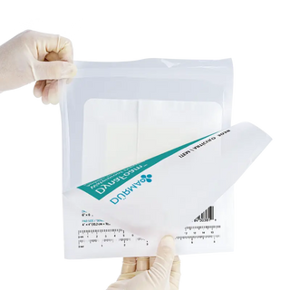 Hand holding a clear plastic bag with medical supplies, branded 'Covidien'.