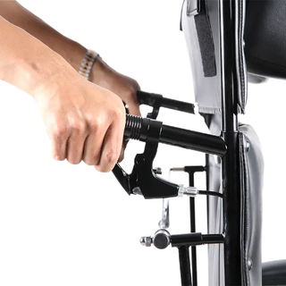 Hand using a lever on a Dynarex Bari+Max Bariatric Reclining Wheelchair w/ ELR piece of exercise equipment with a white background