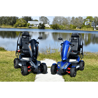Two mobility scooters, one black and one blue, parked on grass near a lake.