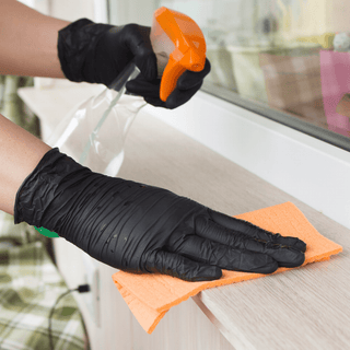 Black Eco Gloves Nitrile Exam Gloves worn while cleaning a surface with a spray bottle