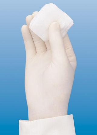 Hand wearing  FLEXAL™ 794316_CS, Nitrile Exam Glove, X-Large, Standard Cuff, Textured Fingertips, Blue holding a white cotton ball against a blue background