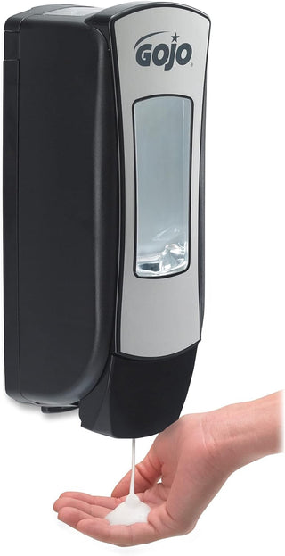 GoJo soap dispenser dispensing soap into a hand on a white background