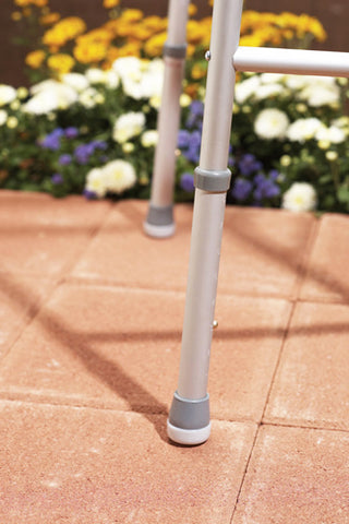  Guardian  sm07904 Walker Glide Caps on a paved surface with flowers in the background