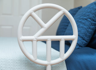 Close-up of the Halo Safety Ring circular handle beside a made bed