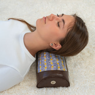Woman lying on a rug with the HealthyLine Amethyst Bolster under her neck