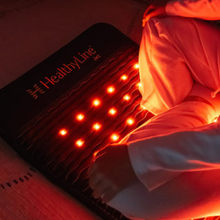 HealthyLine Jet mat with red lights glowing under a white shirt