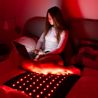 Woman using a laptop on the glowing HealthyLine Jet mat