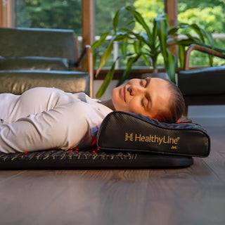 Woman resting her head on the HealthyLine Jet Pillow on a mat