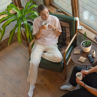 Woman sitting in a chair on the smaller HealthyLine Mesh JT mat