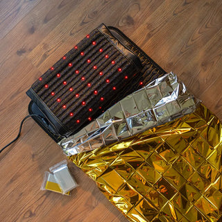 HealthyLine mylar blanket spread next to a heating mat and pillow