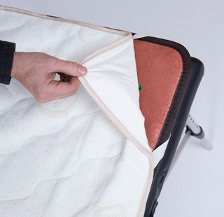Hand lifting the HealthyLine padded cover from a mat