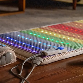 Lit HealthyLine Rainbow Chakra mat beside its controller