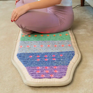 Person kneeling on a HealthyLine Rainbow Chakra Chair mat