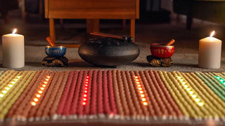 Lit HealthyLine Rainbow Chakra mat by candlelight