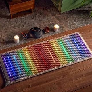 Lit HealthyLine Rainbow Chakra mat beside candles