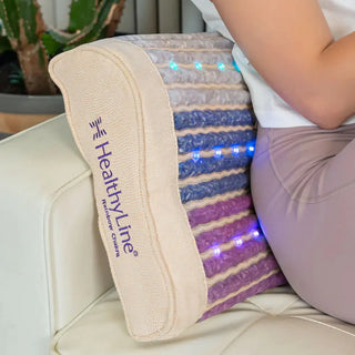 HealthyLine Rainbow Chakra Pillow behind a person on a couch
